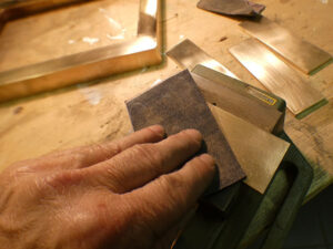 hand that is polishing a piece of brass
